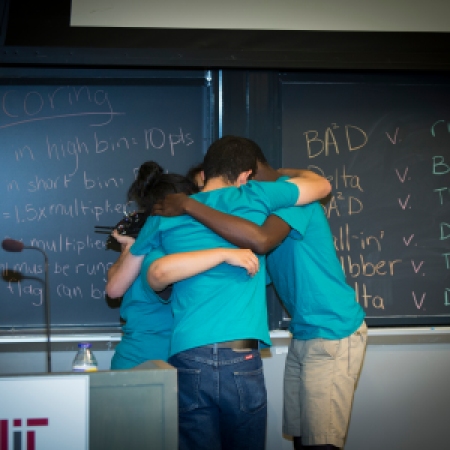 An Engineering Design team huddles before resuming competition in the final Symposium game.